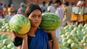A female labourer carried away watermelons following an auction at the Gaddiannaram wholesale fruit market on the outskirts of Hyderabad. © NOAH SEELAM/AFP/Getty Images