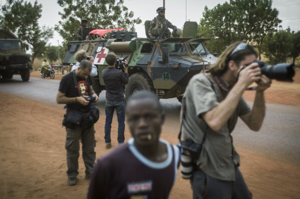 Photographers take pictures of a tank in Mali