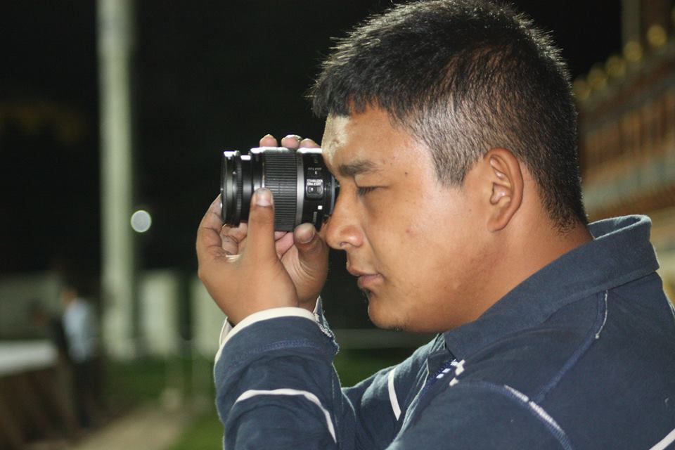 Tenzin looks through a camera lens