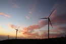wind turbines on a wide plain against backdrop of sunset