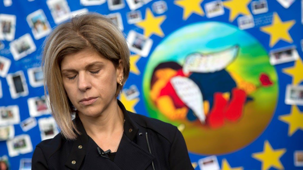Fatima Kurdi, from Canada, stands next to a painting of her late nephew, Aylan Kurdi, on a board outside of EU headquarters on Monday, Sept. 14, 2015. Aylan Kurdi (3) and his family was on the way to her when the small rubber boat he and his family were in capsized in a desperate voyage from Turkey to Greece. © picture-alliance/AP Photo/V. Mayo